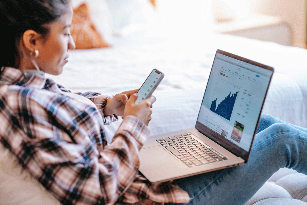 woman with data on phone and laptop