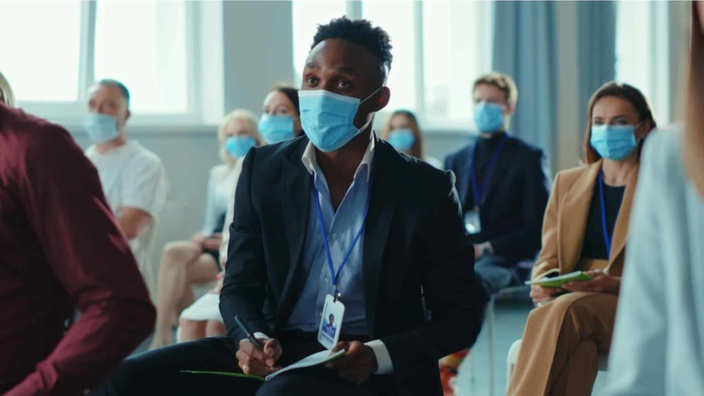 Event attendees social distancing with masks