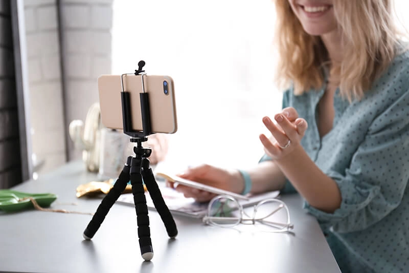 woman with iphone in a tabletop tripod